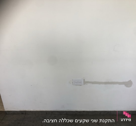 שקע חשמל כפול על קיר לבן עם תיקון טיח